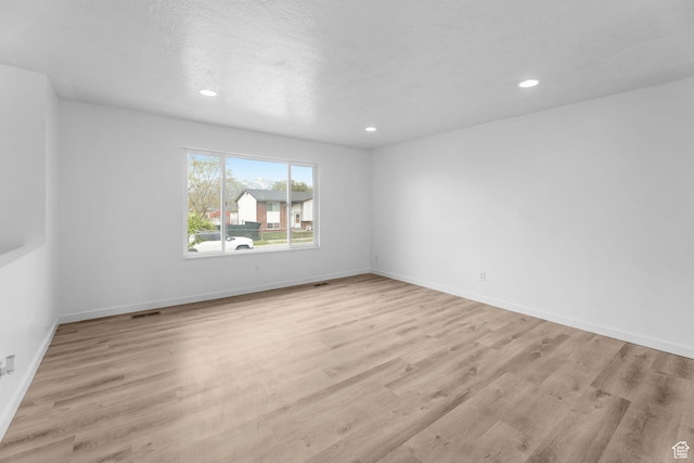 spare room featuring baseboards, wood finished floors, and recessed lighting