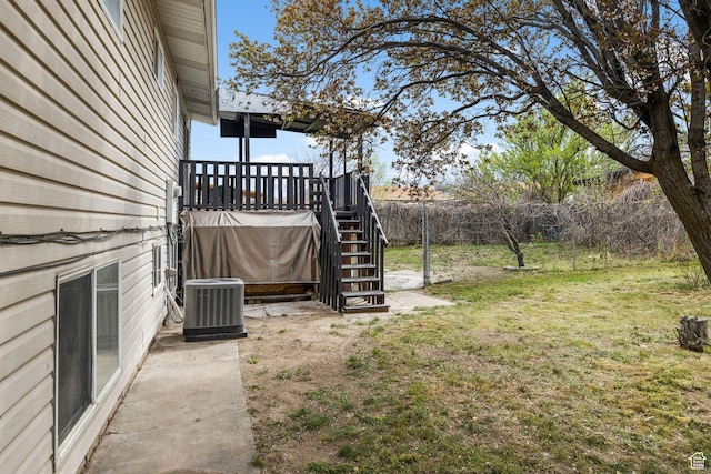 view of yard with fence, a deck, stairs, and central AC unit