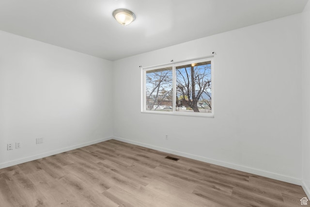 unfurnished room featuring baseboards, visible vents, and light wood-type flooring