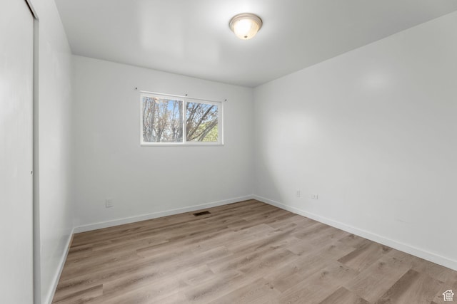 spare room with baseboards, visible vents, and light wood-style flooring