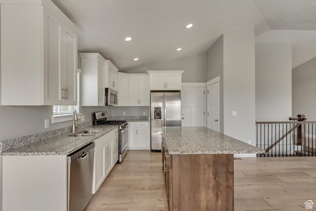 462 S 1430 E Unit 114, Tooele, UT 84074 - kitchen with stainless steel appliances, a center island, a sink, light wood-type flooring, and lofted ceiling