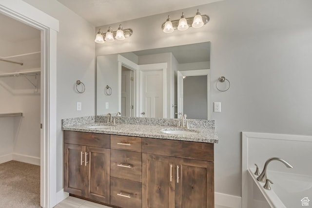 462 S 1430 E Unit 114, Tooele, UT 84074 - full bath featuring a walk in closet, double vanity, baseboards, and a sink