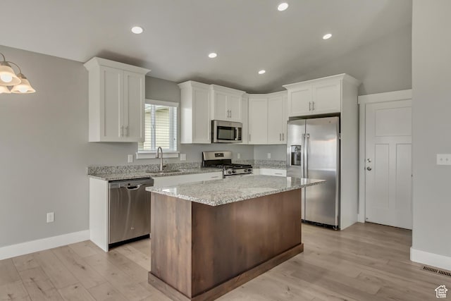 462 S 1430 E Unit 114, Tooele, UT 84074 - kitchen featuring a center island, a sink, light wood-type flooring, white cabinets, and appliances with stainless steel finishes