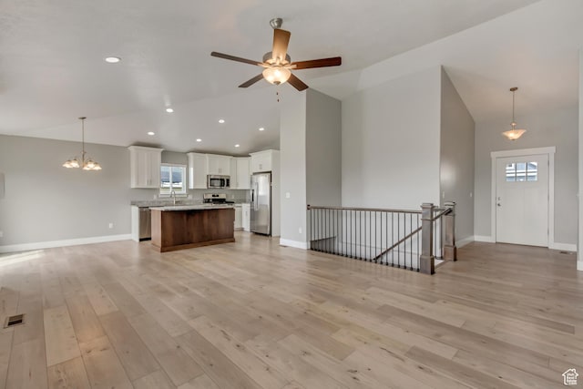 462 S 1430 E Unit 114, Tooele, UT 84074 - kitchen with high vaulted ceiling, open floor plan, white cabinets, baseboards, and appliances with stainless steel finishes