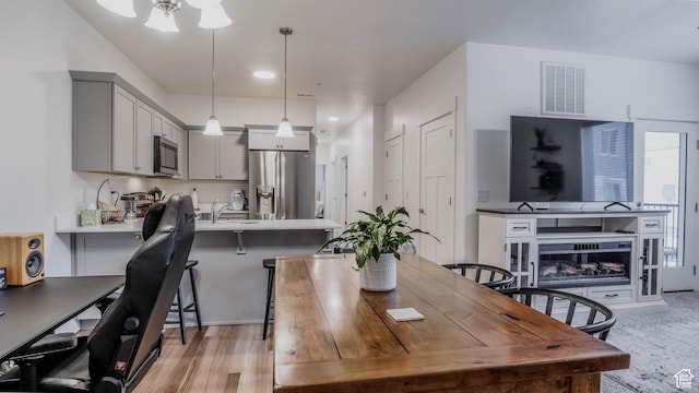 1984 N 3410 W Unit R102, Lehi, UT 84043 - dining room with light wood-style floors, visible vents, and a fireplace