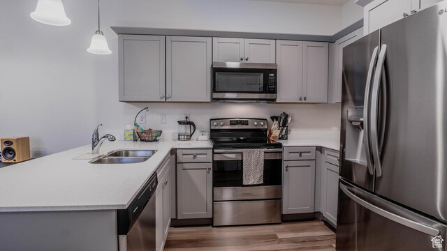 1984 N 3410 W Unit R102, Lehi, UT 84043 - kitchen featuring stainless steel appliances, a peninsula, a sink, light wood-type flooring, and gray cabinets