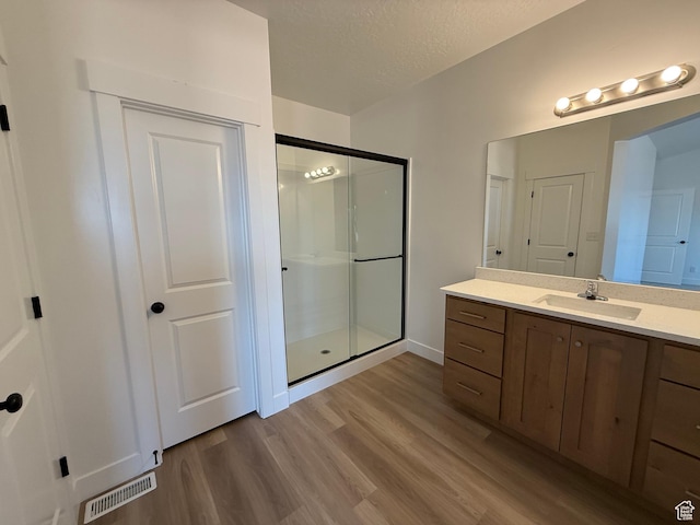 1975 S Marigold Way Unit 433, Santaquin, UT 84655 - bathroom featuring a stall shower, wood finished floors, vanity, and a textured ceiling