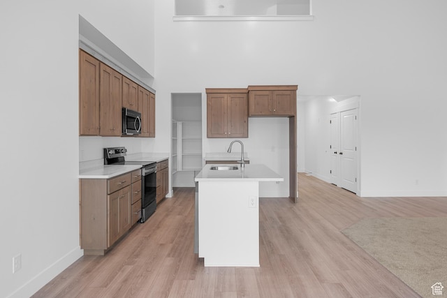 1975 S Marigold Way Unit 433, Santaquin, UT 84655 - kitchen with appliances with stainless steel finishes, a high ceiling, light countertops, light wood-style floors, and brown cabinets