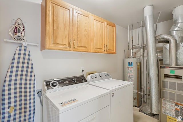 washroom featuring water heater, washing machine and clothes dryer, and cabinet space