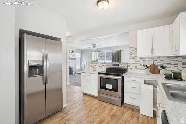 2662 Jackson Ave, Ogden, UT 84401 - kitchen featuring backsplash, white cabinetry, a ceiling fan, and stainless steel appliances