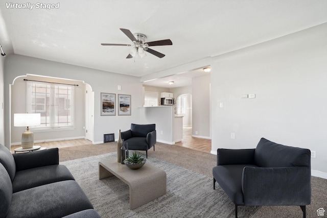 2662 Jackson Ave, Ogden, UT 84401 - living area with a ceiling fan, baseboards, arched walkways, and light colored carpet