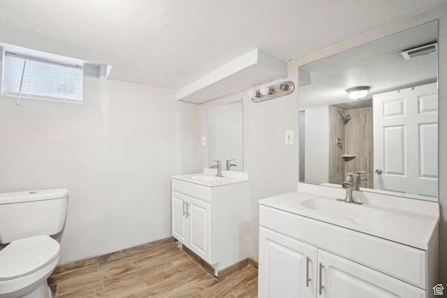 2662 Jackson Ave, Ogden, UT 84401 - full bathroom with two vanities, wood finished floors, visible vents, and a sink