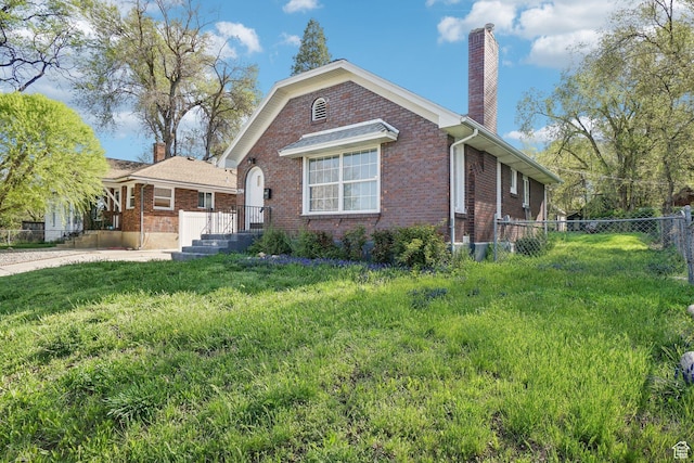2662 Jackson Ave, Ogden, UT 84401 - bungalow-style house featuring fence, a front lawn, a chimney, and brick siding