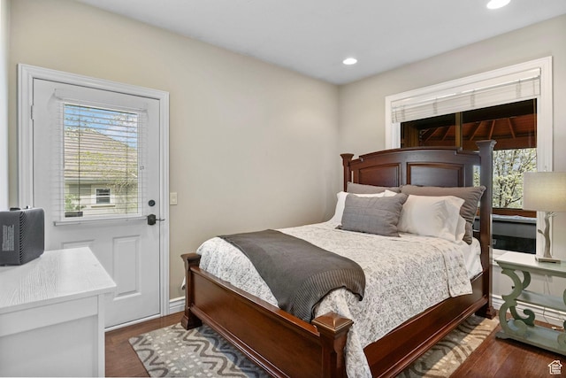 bedroom featuring baseboards, wood finished floors, recessed lighting, and multiple windows