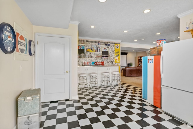 interior space featuring freestanding refrigerator, tile patterned floors, and crown molding