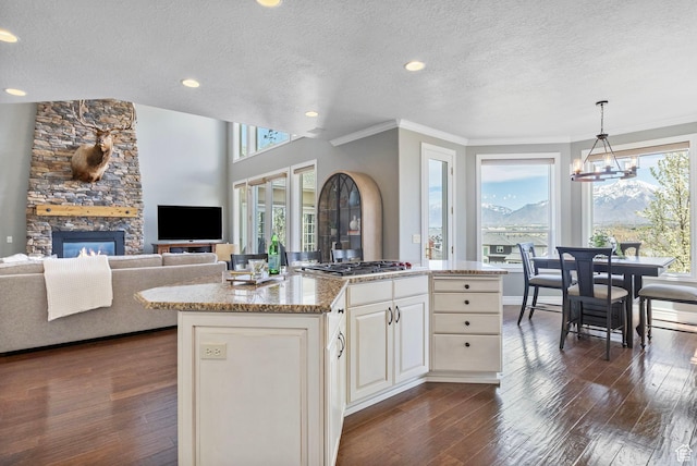 kitchen featuring stainless steel gas cooktop, a textured ceiling, and a healthy amount of sunlight
