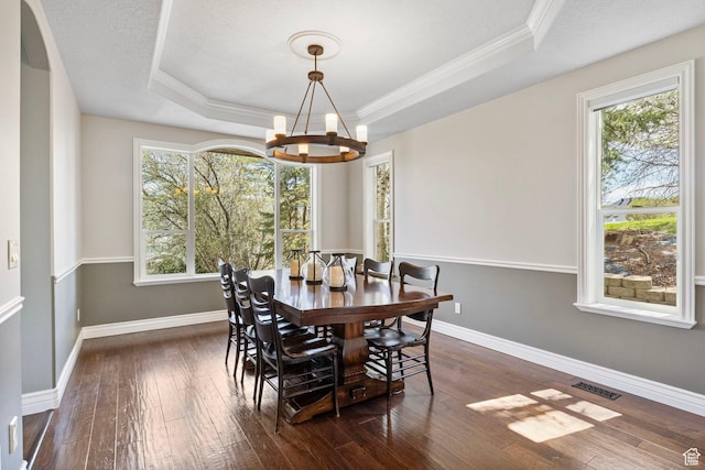 dining space with a tray ceiling, visible vents, a healthy amount of sunlight, and an inviting chandelier