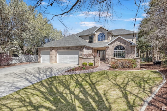 traditional home with roof with shingles, a front lawn, driveway, brick siding, and an attached garage
