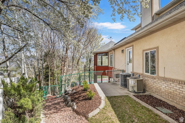 view of yard with fence, a patio, and central AC unit