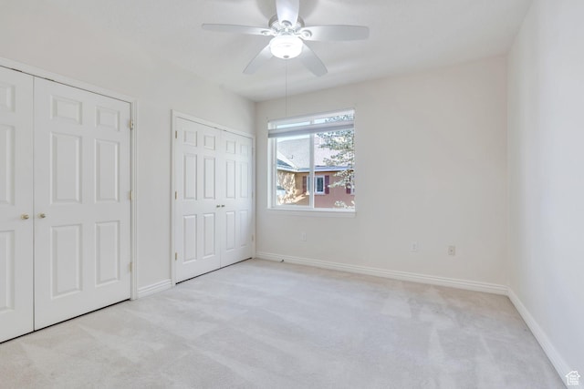 502 S 1040 E Unit 235C, American Fork, UT 84003 - unfurnished bedroom featuring light carpet, a ceiling fan, baseboards, and two closets