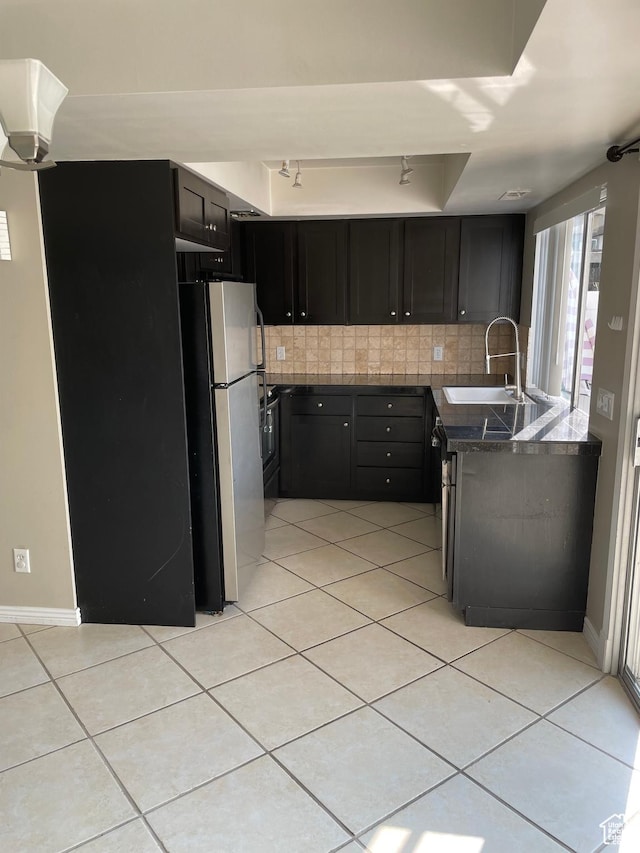 1525 E 5700 S, Murray, UT 84121 - kitchen featuring tasteful backsplash, a sink, light tile patterned flooring, dark cabinets, and freestanding refrigerator