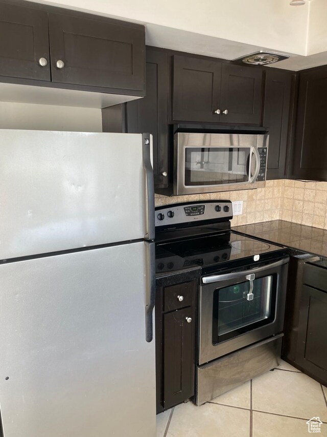 1525 E 5700 S, Murray, UT 84121 - kitchen with dark countertops, tasteful backsplash, stainless steel appliances, and light tile patterned floors