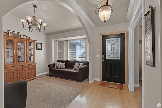 2838 N 1375 E, North Ogden, UT 84414 - entryway featuring arched walkways, light wood-style floors, a chandelier, and baseboards