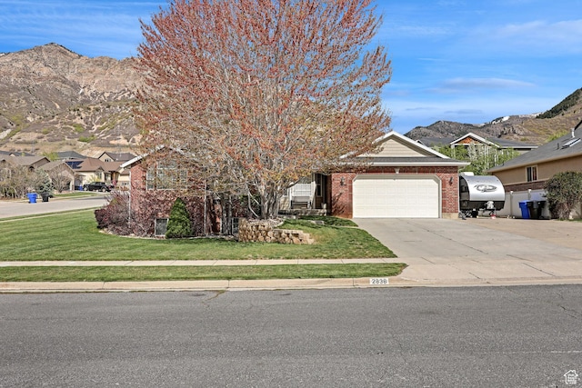 2838 N 1375 E, North Ogden, UT 84414 - view of property hidden behind natural elements with a front lawn, concrete driveway, brick siding, a mountain view, and a garage