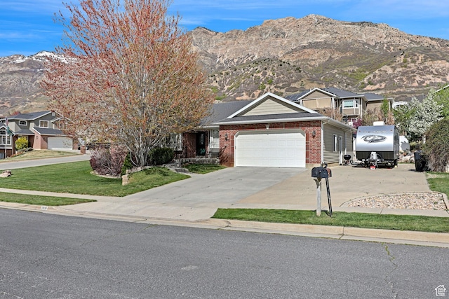 2838 N 1375 E, North Ogden, UT 84414 - view of front facade featuring a front lawn, driveway, a mountain view, a garage, and brick siding