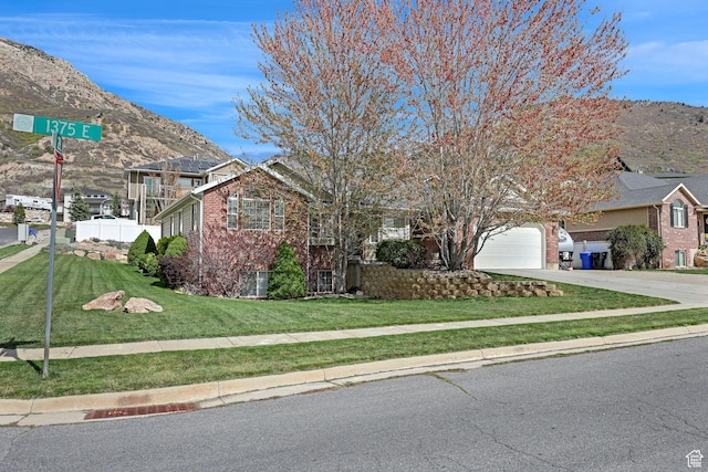 2838 N 1375 E, North Ogden, UT 84414 - view of front of house featuring a front lawn, driveway, brick siding, and a mountain view
