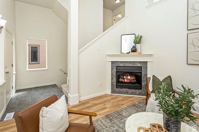 917 W Willow Bend Way, Farmington, UT 84025 - living room with a tile fireplace, a high ceiling, wood finished floors, visible vents, and stairs