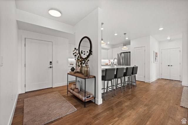 entryway with baseboards, wood finished floors, and recessed lighting
