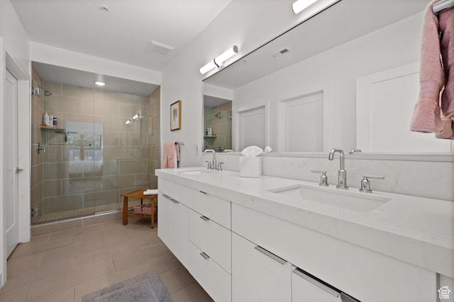 bathroom with a shower stall, a sink, and visible vents