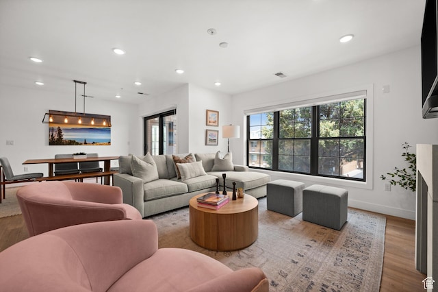 living room with recessed lighting, wood finished floors, visible vents, and baseboards