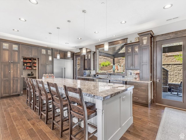 15146 S Secret Canyon Cir, Herriman, UT 84096 - kitchen with recessed lighting, dark wood finished floors, stainless steel built in fridge, and a large island