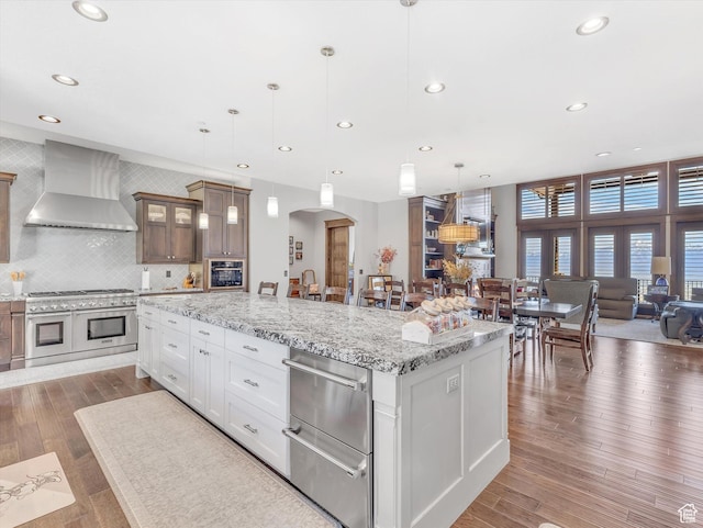 15146 S Secret Canyon Cir, Herriman, UT 84096 - kitchen with arched walkways, wall chimney range hood, range with two ovens, and recessed lighting