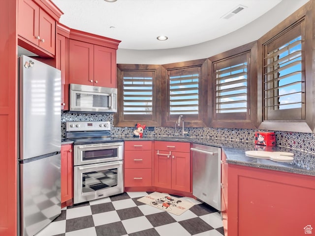 15146 S Secret Canyon Cir, Herriman, UT 84096 - kitchen featuring a sink, dark countertops, visible vents, light floors, and appliances with stainless steel finishes