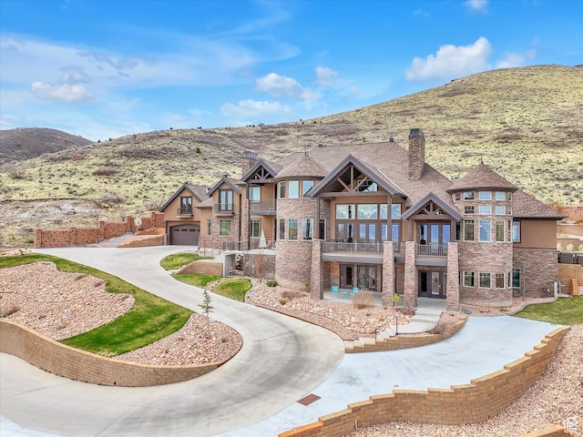 15146 S Secret Canyon Cir, Herriman, UT 84096 - view of front of property featuring stone siding, a chimney, a balcony, and a mountain view
