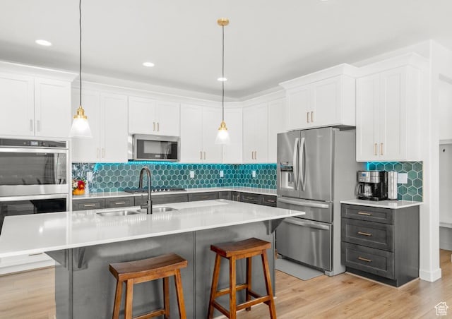 kitchen featuring white cabinets, stainless steel appliances, and a breakfast bar area