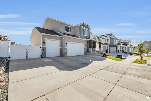 view of front of property featuring a residential view, a gate, concrete driveway, an attached garage, and stucco siding