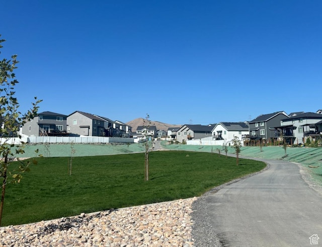 view of property's community with a yard, a residential view, and fence