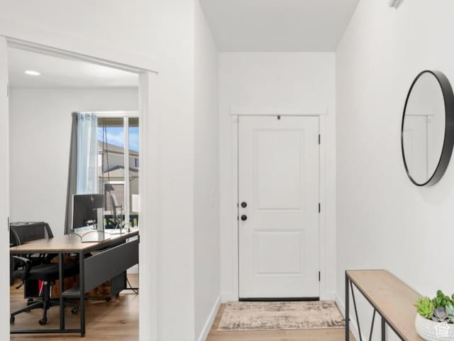 foyer entrance featuring light wood finished floors and baseboards