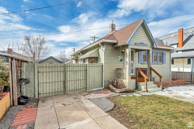 2481 Van Buren Ave, Ogden, UT 84401 - bungalow-style home with fence, a shingled roof, a chimney, and a gate