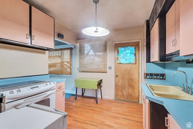 2481 Van Buren Ave, Ogden, UT 84401 - kitchen featuring light countertops, electric stove, a sink, light wood-style floors, and pendant lighting