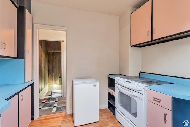2481 Van Buren Ave, Ogden, UT 84401 - kitchen with light countertops, white electric range oven, light wood-style floors, and refrigerator