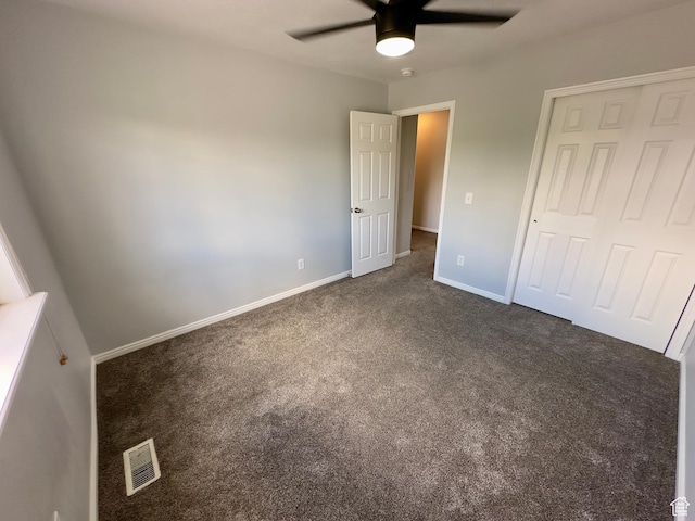 unfurnished bedroom with dark carpet, baseboards, and ceiling fan