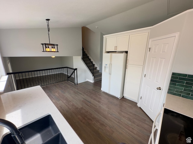 unfurnished living room with dark wood-type flooring, vaulted ceiling, and a sink