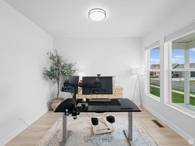 workout room with plenty of natural light, baseboards, and wood finished floors