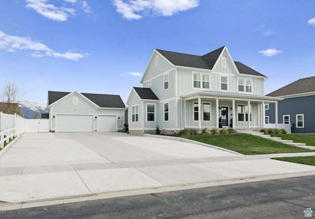 modern farmhouse style home featuring board and batten siding, a porch, an attached garage, and concrete driveway