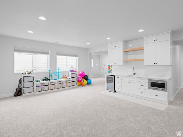 game room with wine cooler, carpet floors, recessed lighting, baseboards, and bar with sink